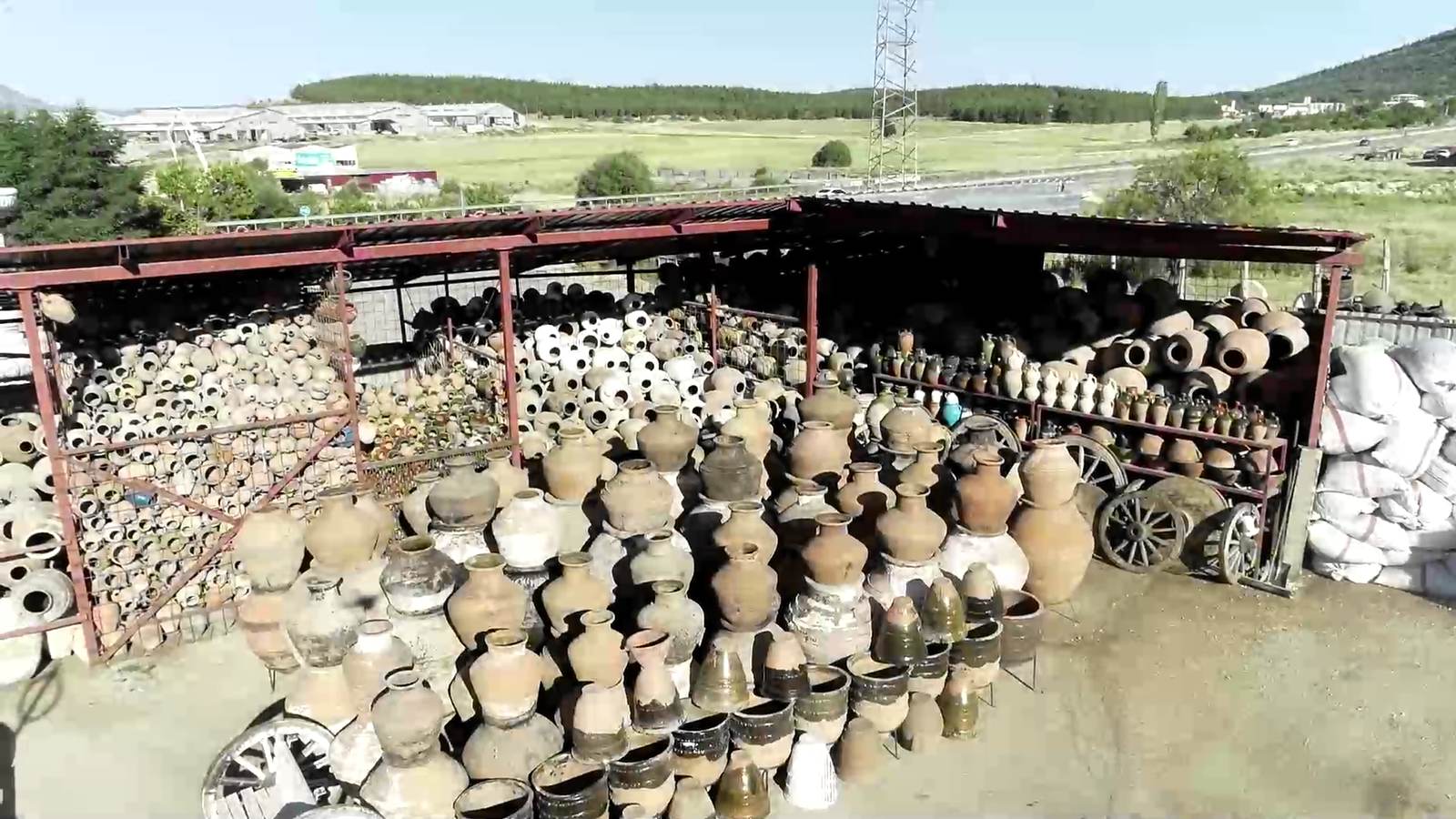 Aerial view of a covered depot yard filled with hundreds of Anatolian clay jars