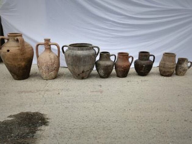 Yoz Amphora, Small — row of eight small weathered clay jugs and amphorae in terracotta and grey