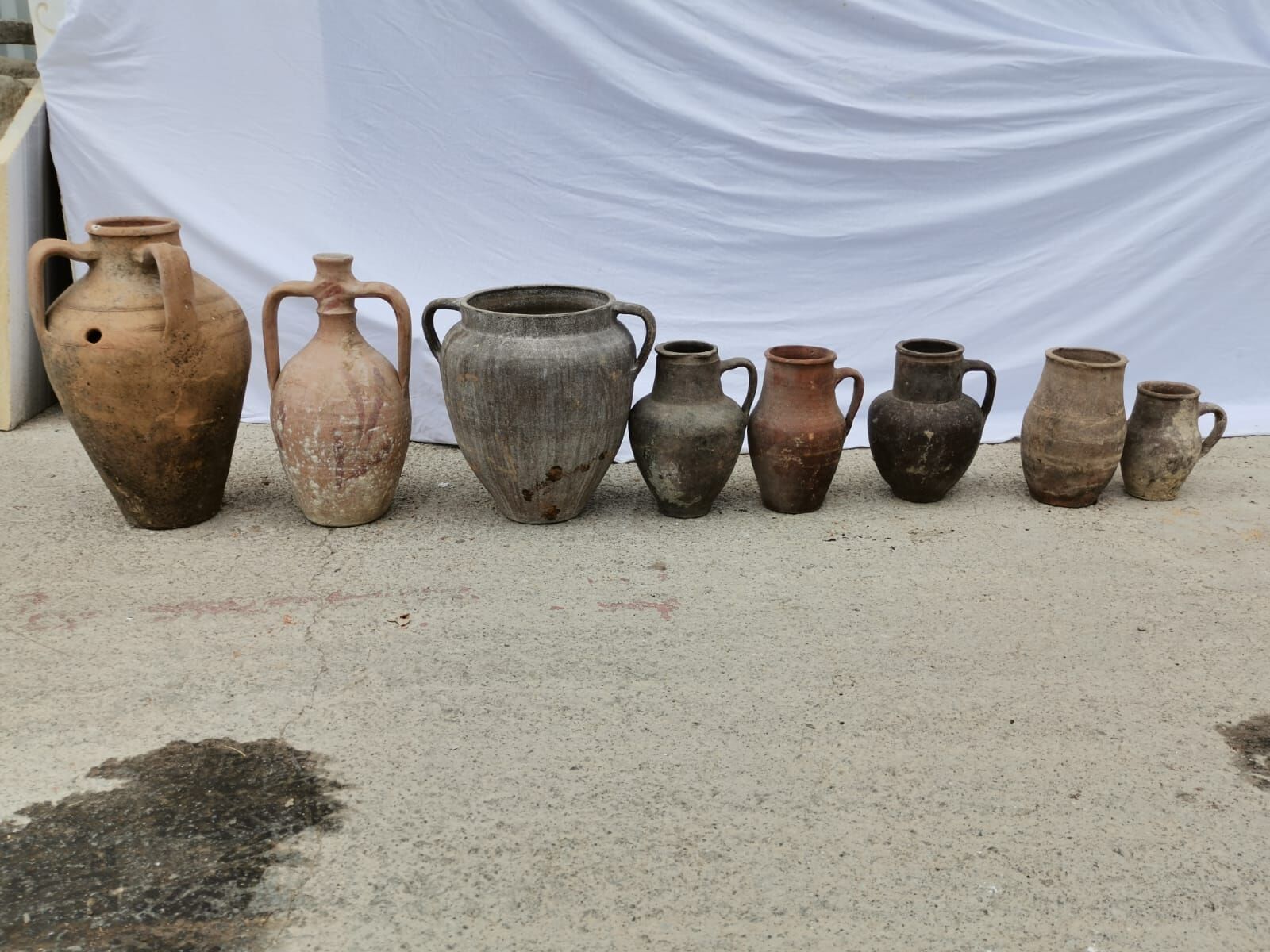 Yoz Amphora, Small — row of small clay jugs and amphorae in terracotta and grey tones