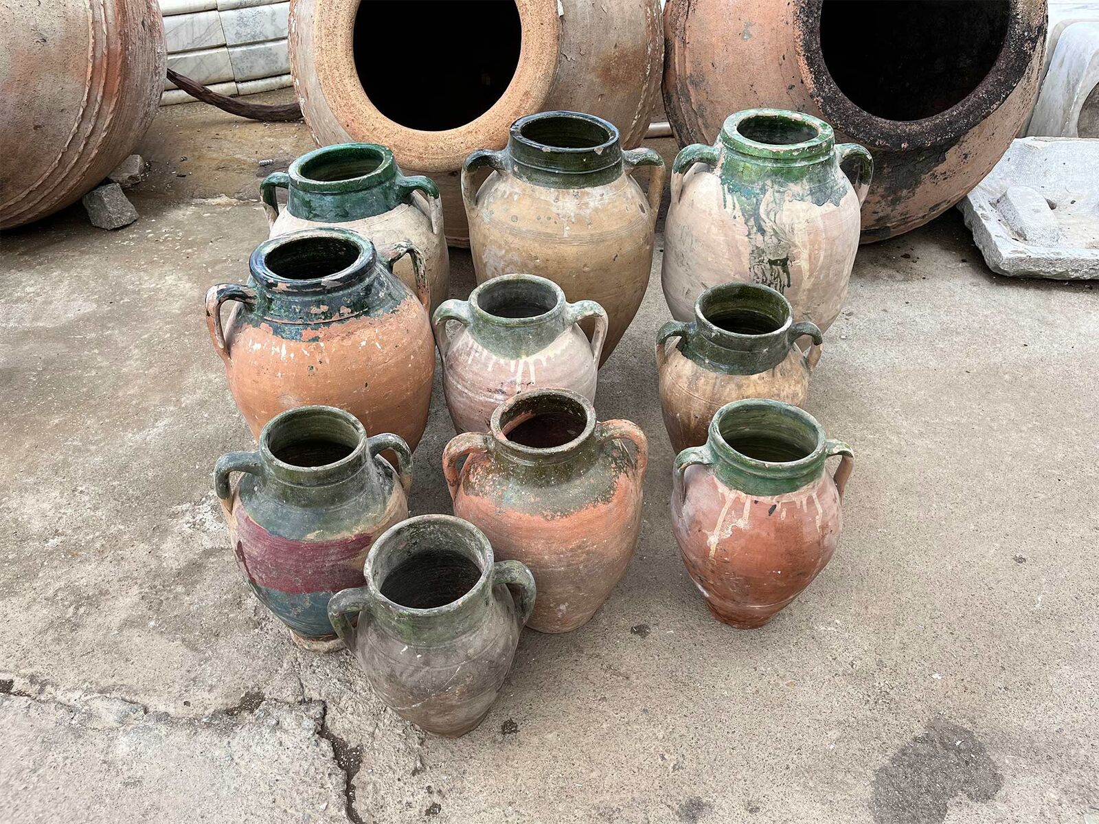 Konya Green Amphora, Small — cluster of small jars with green-glazed necks on a concrete yard