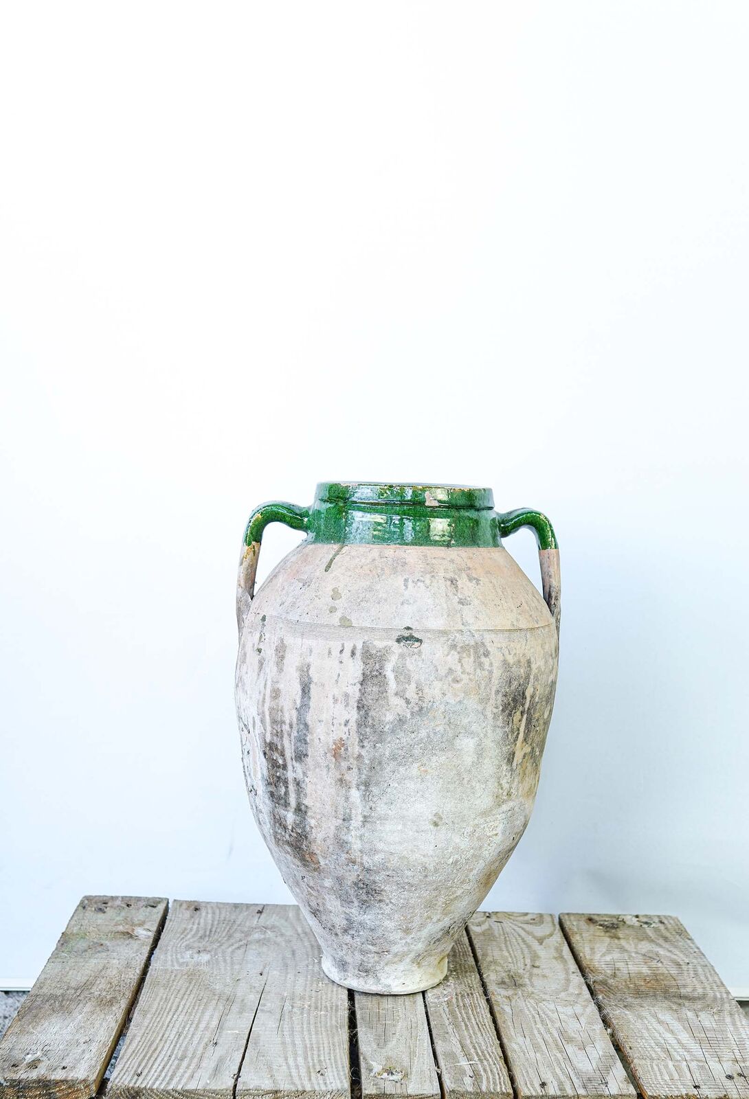 Konya Green Amphora, Large — pale weathered jar with a green-glazed neck and handles on a wooden pallet