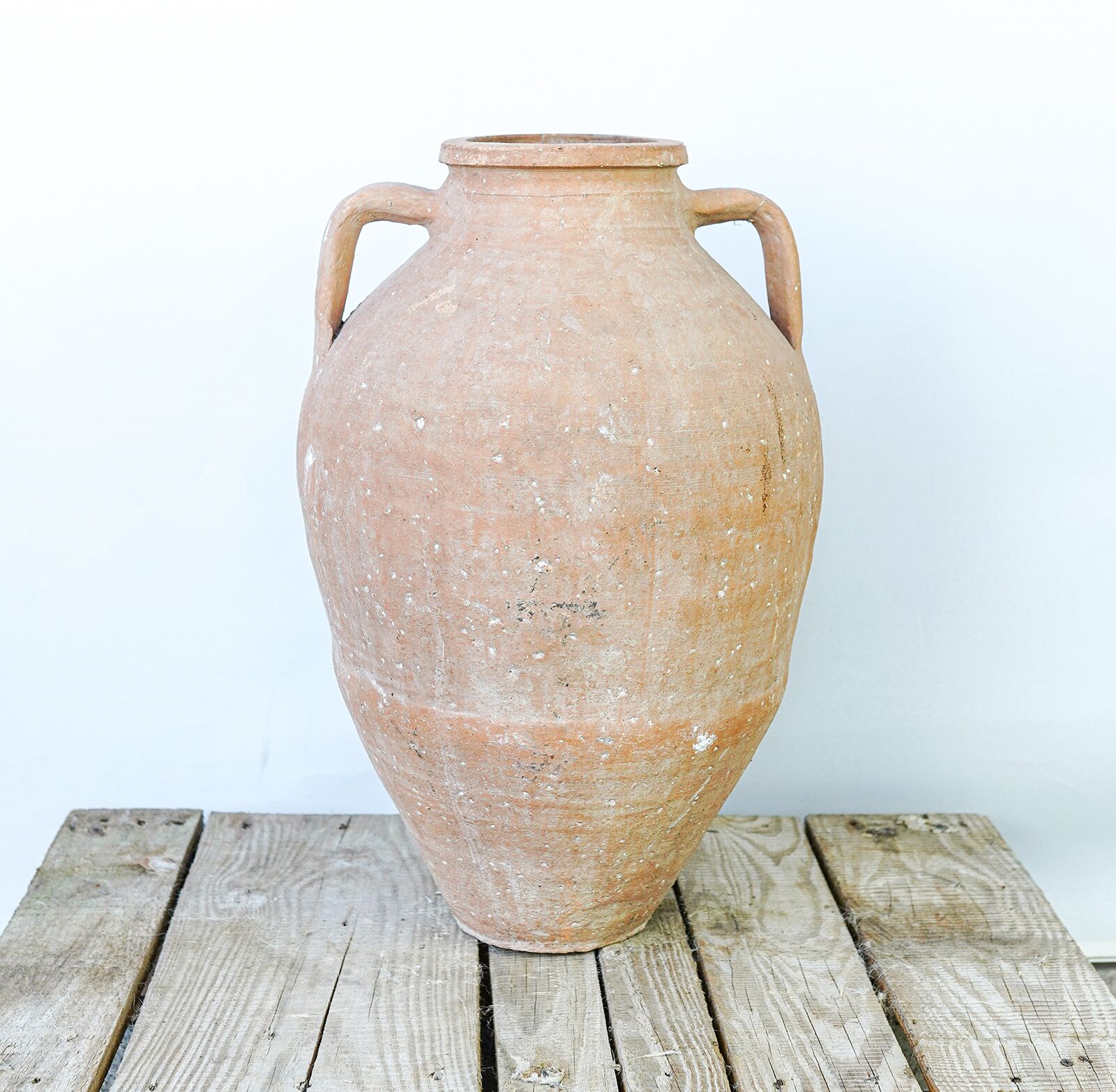 Mid-Size Anatolian Pot — tall terracotta jar with two handles on a wooden pallet