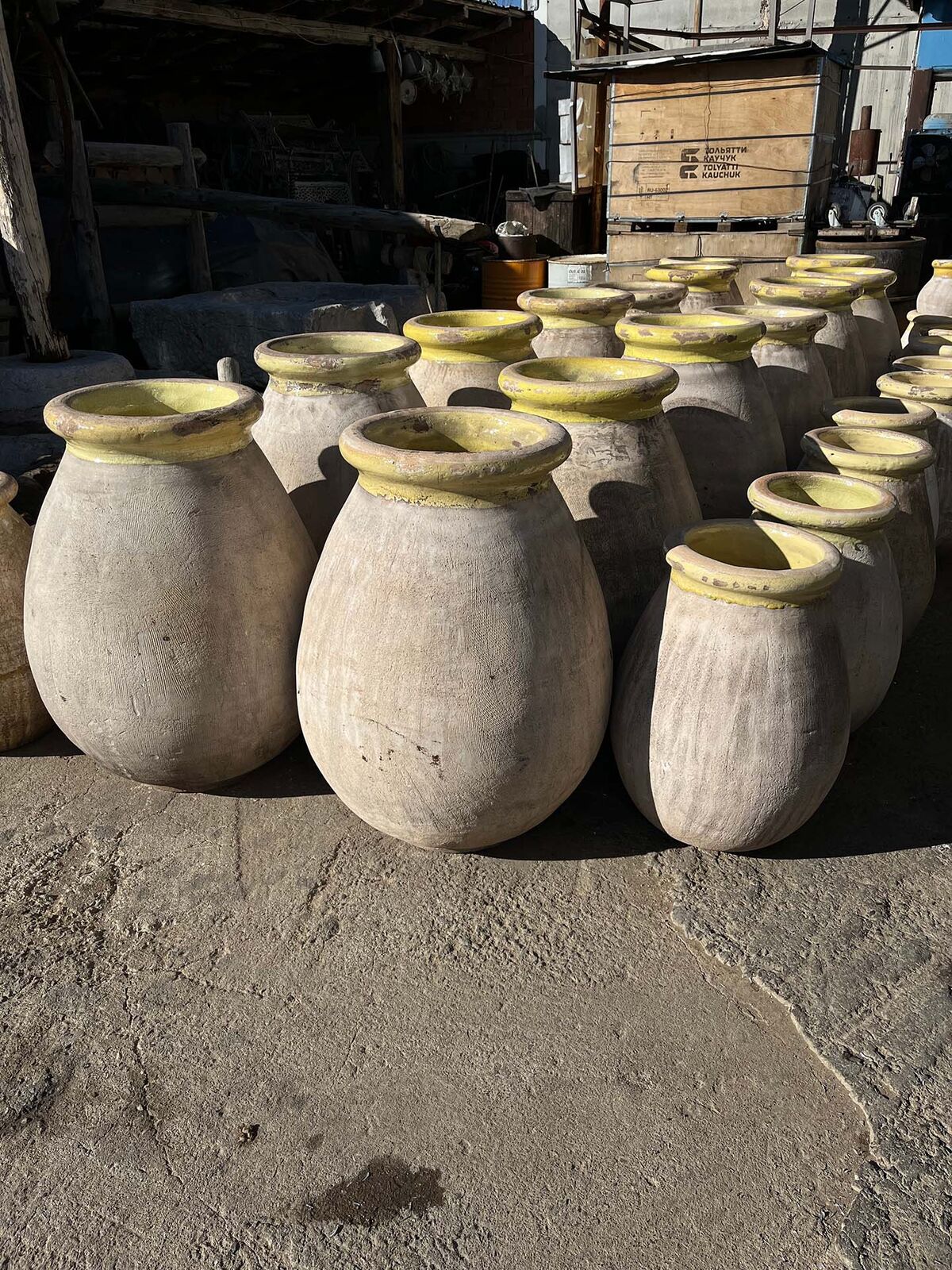 Cream Olive Jar, Yellow Rim — tall cream clay jars with yellow-glazed rims standing together