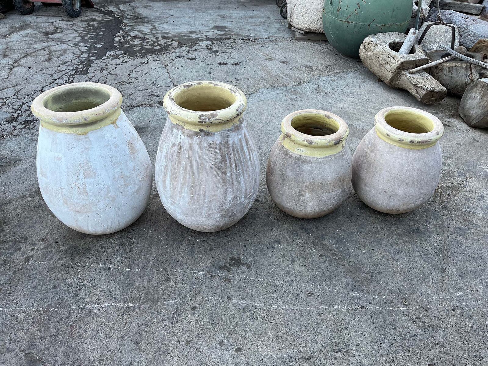 Cream Olive Jar, Yellow Rim — group of white clay jars with yellow rims on a paved yard