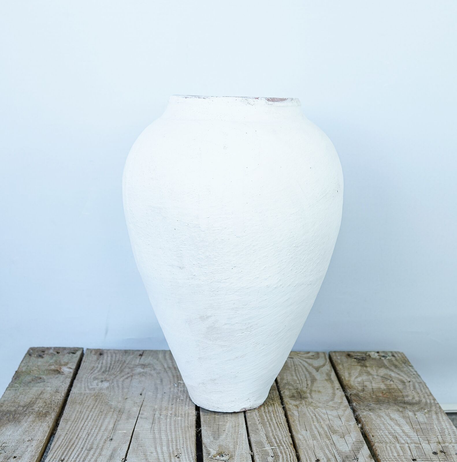 Whitewashed Smooth Jar, Large — tall smooth white clay jar with a broad shoulder on a wooden pallet