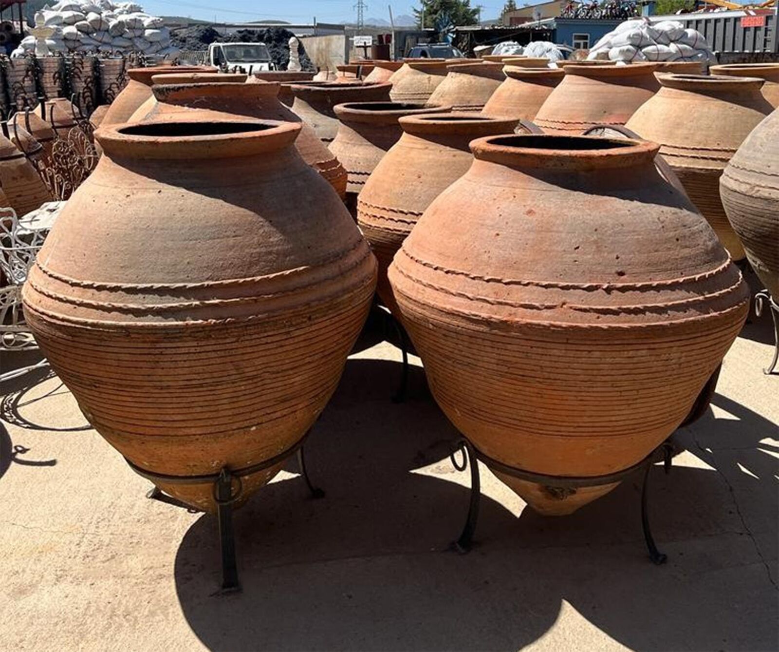 Enez Jar, Medium — two large rounded terracotta jars on iron stands