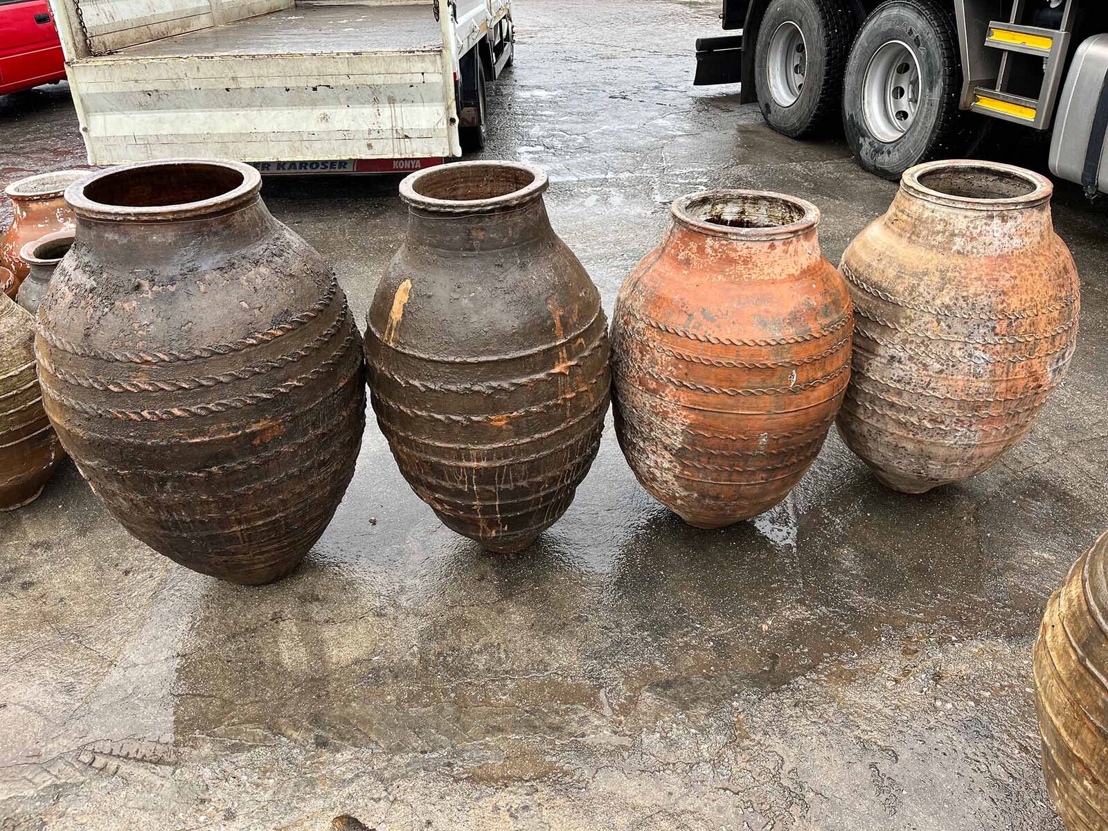 Monumental Oil Jar on Stand — row of large clay jars in warm brown and grey tones