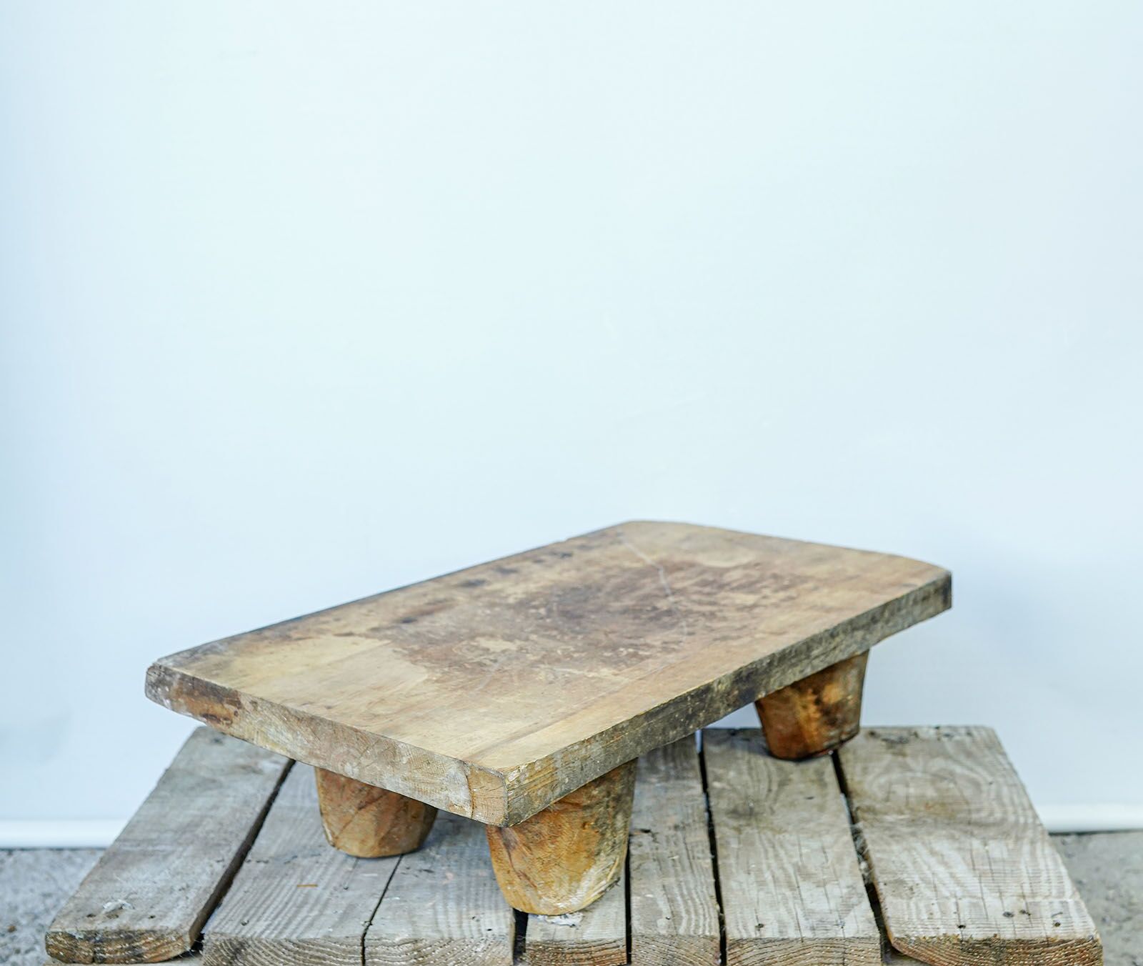 Senit Wood Board — low wooden table on rounded legs standing on a pallet