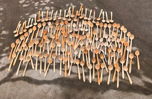Wooden spoons in pale timber arranged in a fan shape on a stone floor
