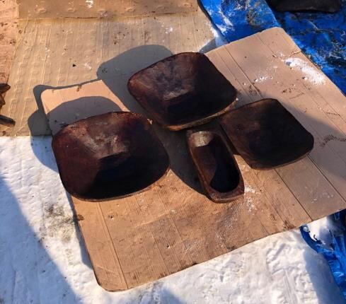 Dark wooden square bowls and a narrow trough placed on a cardboard sheet
