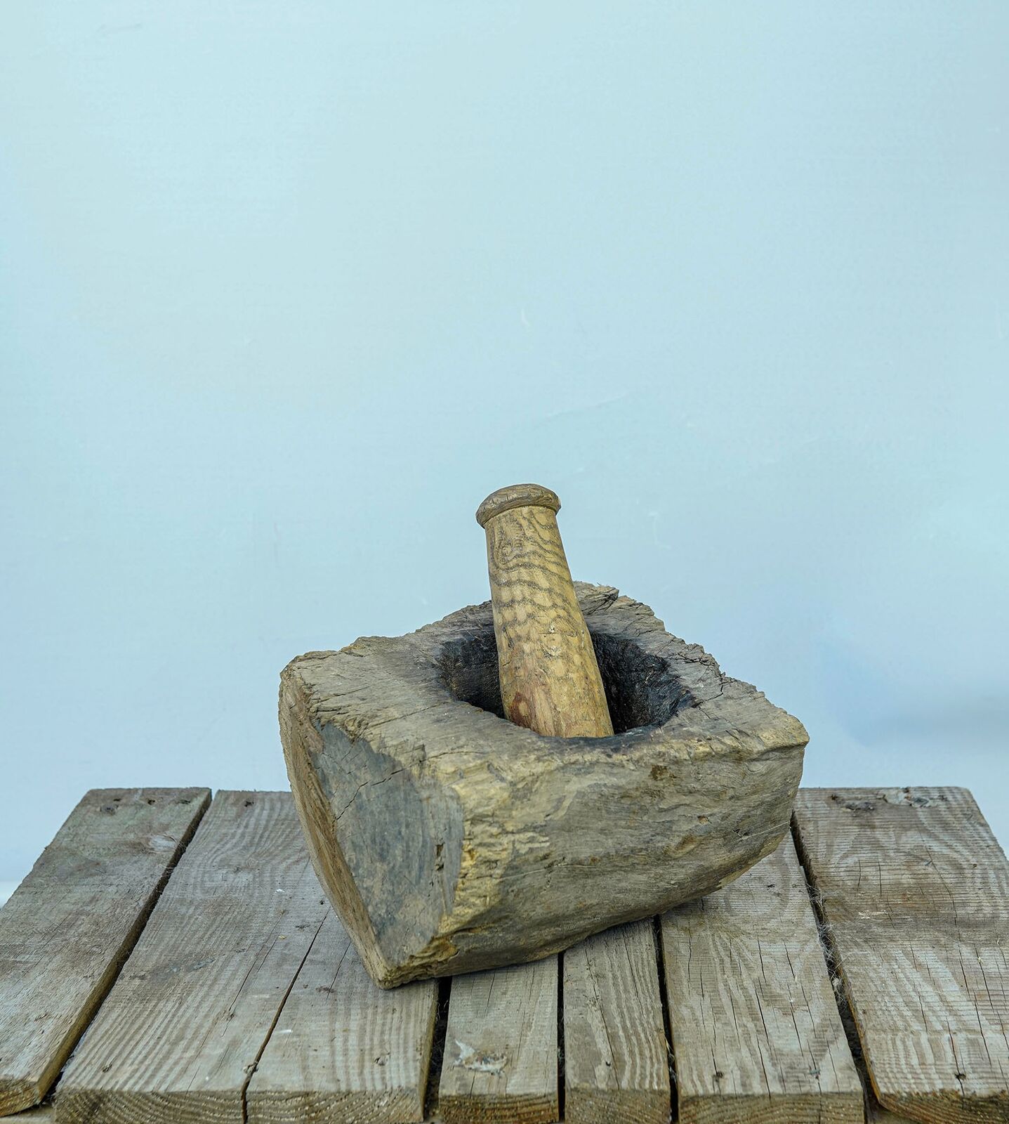 Wooden Mortar with Pestle — deep wooden mortar with a wooden pestle on a pallet