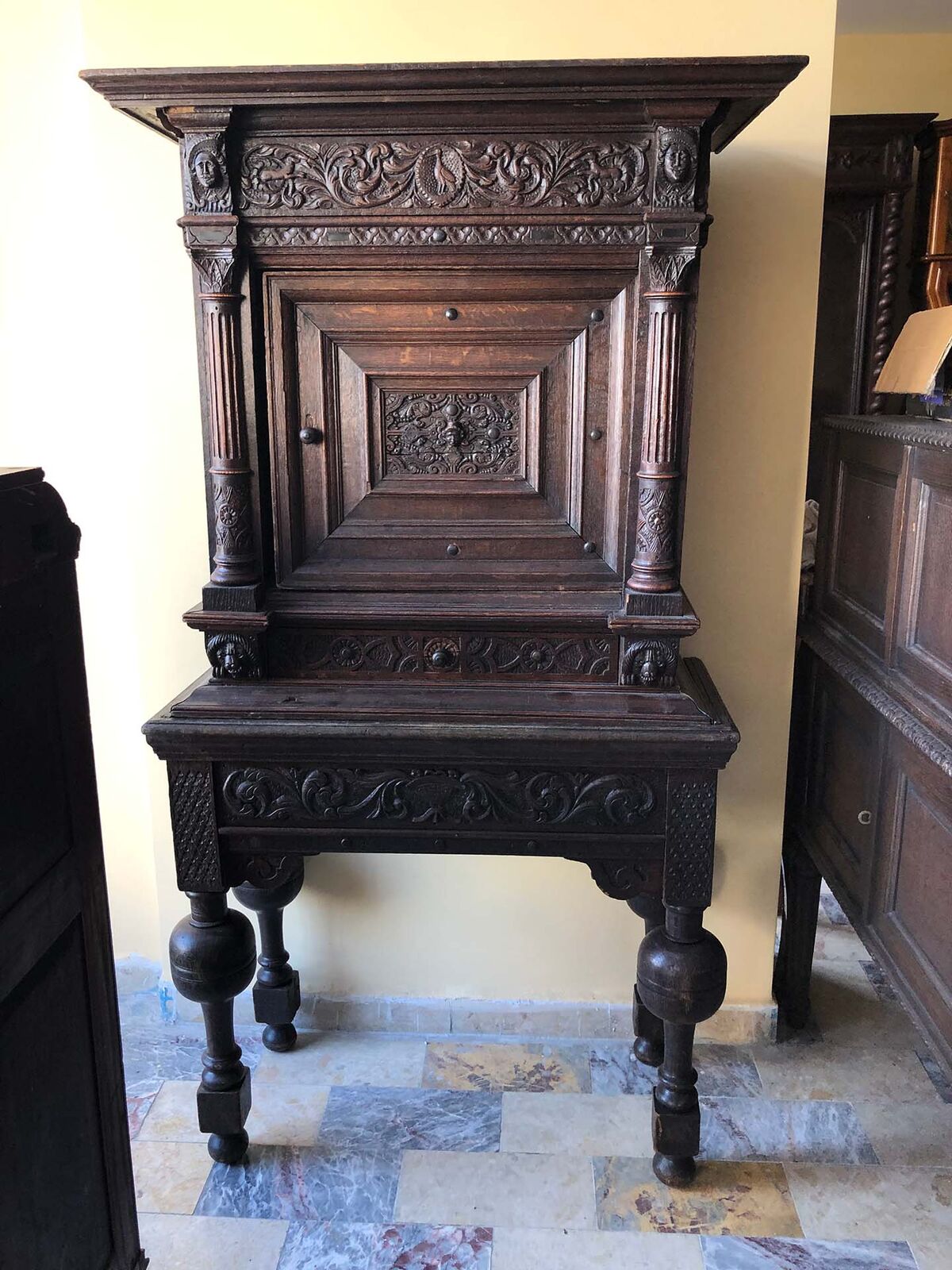 Carved Wooden Cabinets and Vitrines — tall carved dark wood cabinet on turned legs