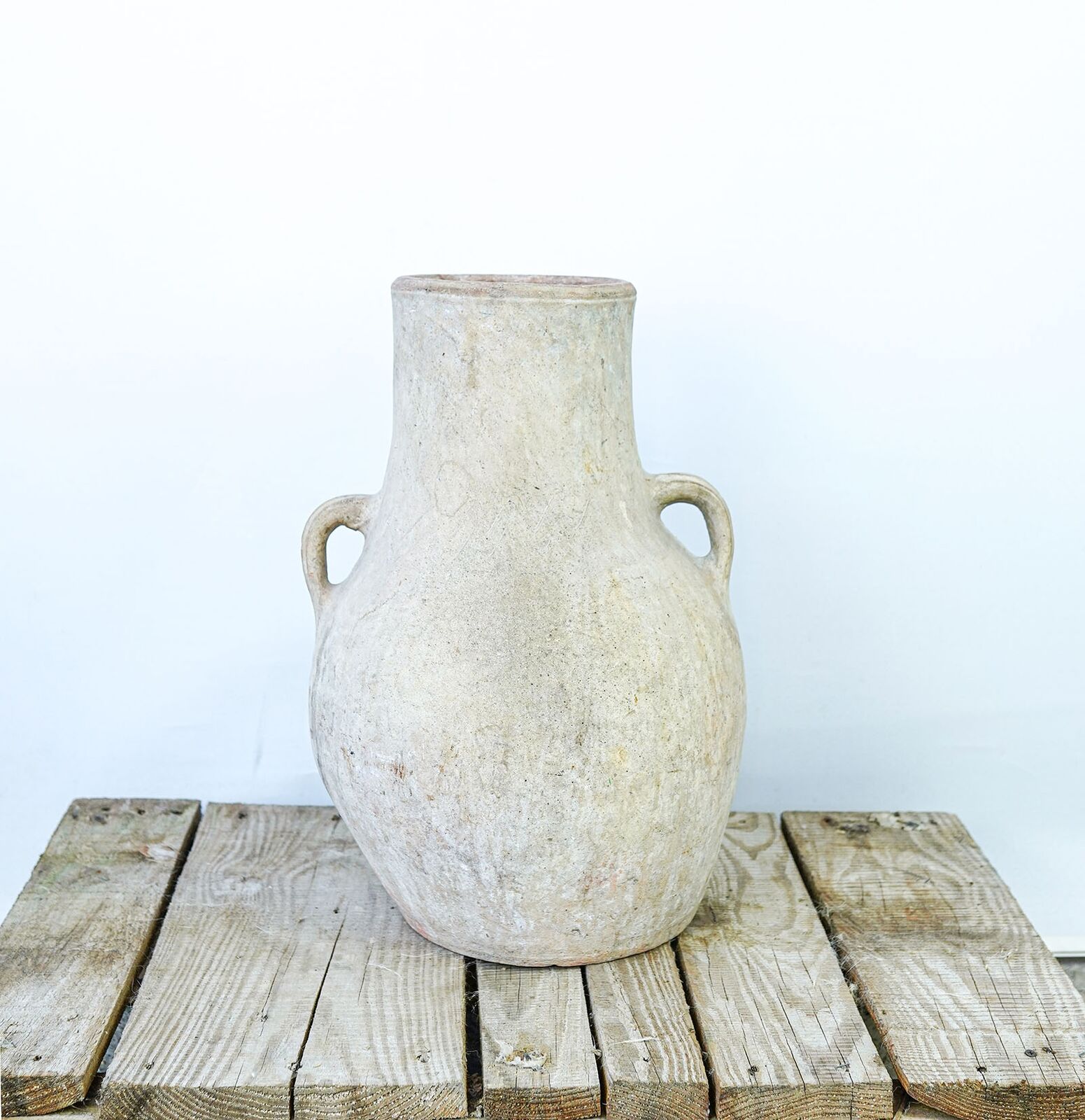 Hatay Amphora — tall pale limewashed amphora with two handles on a pallet