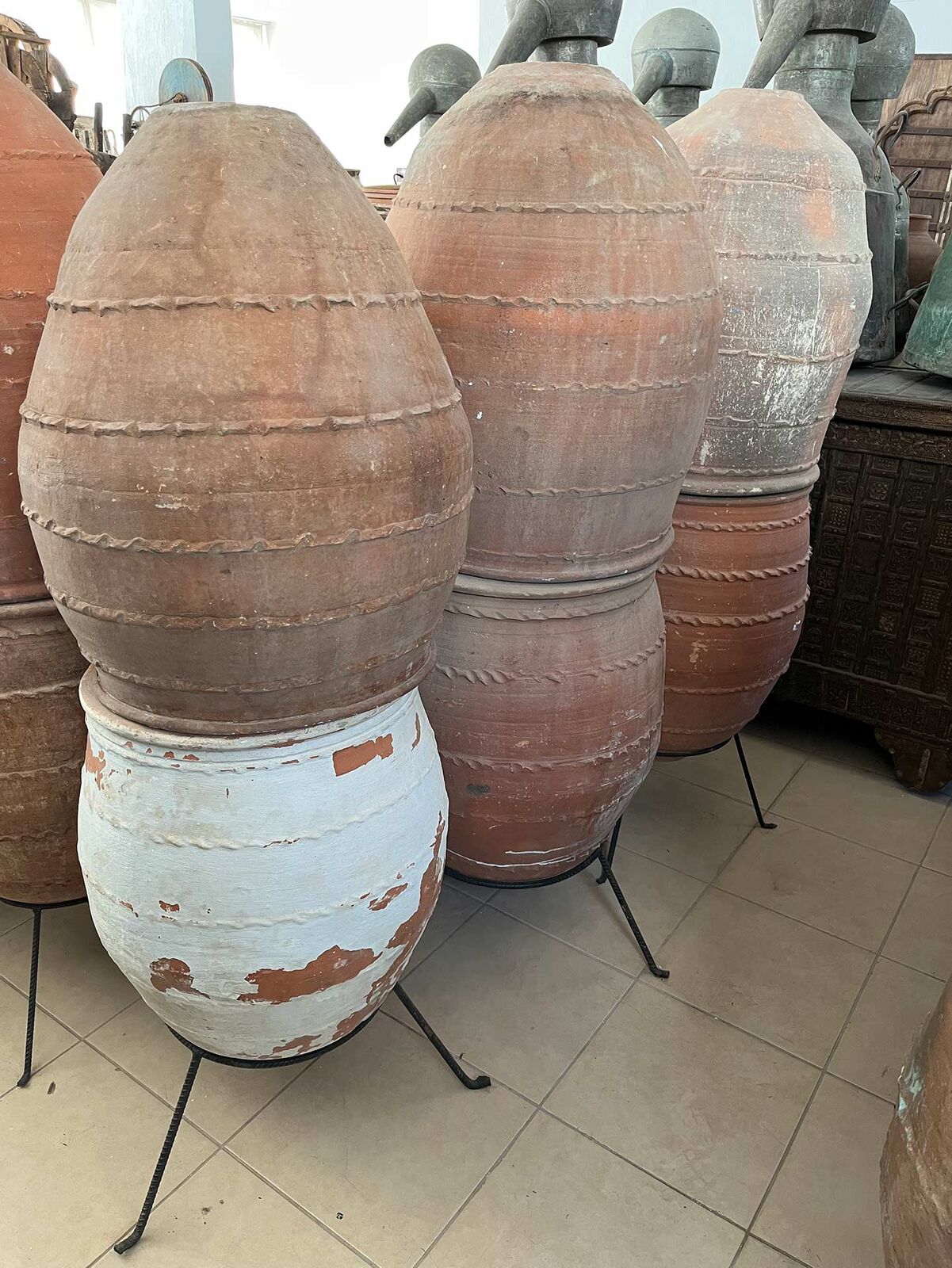 Dağar Storage Jar — terracotta egg-shaped jars with belts on iron stands