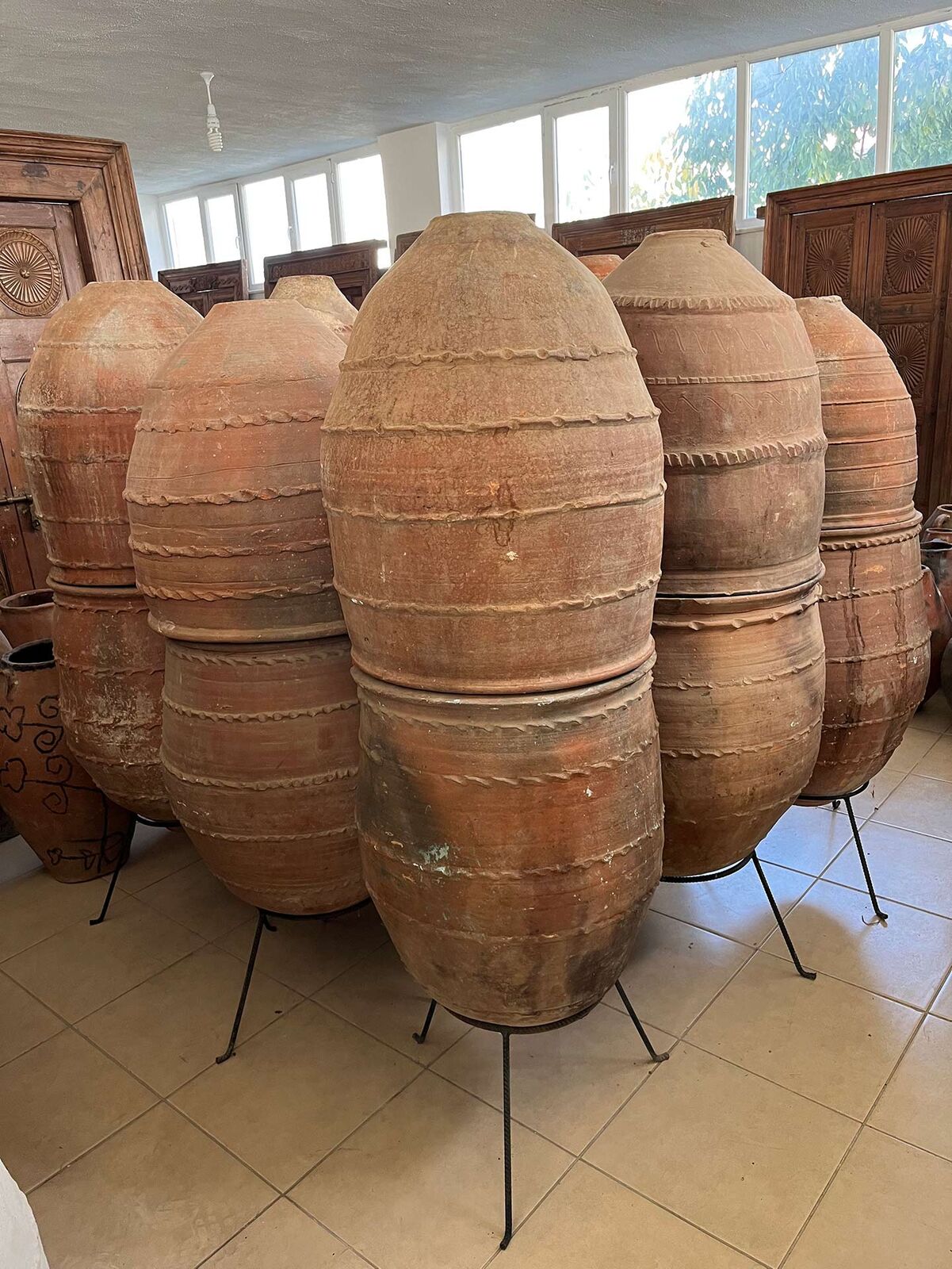 Dağar Storage Jar — tall terracotta belted jars standing on iron stands