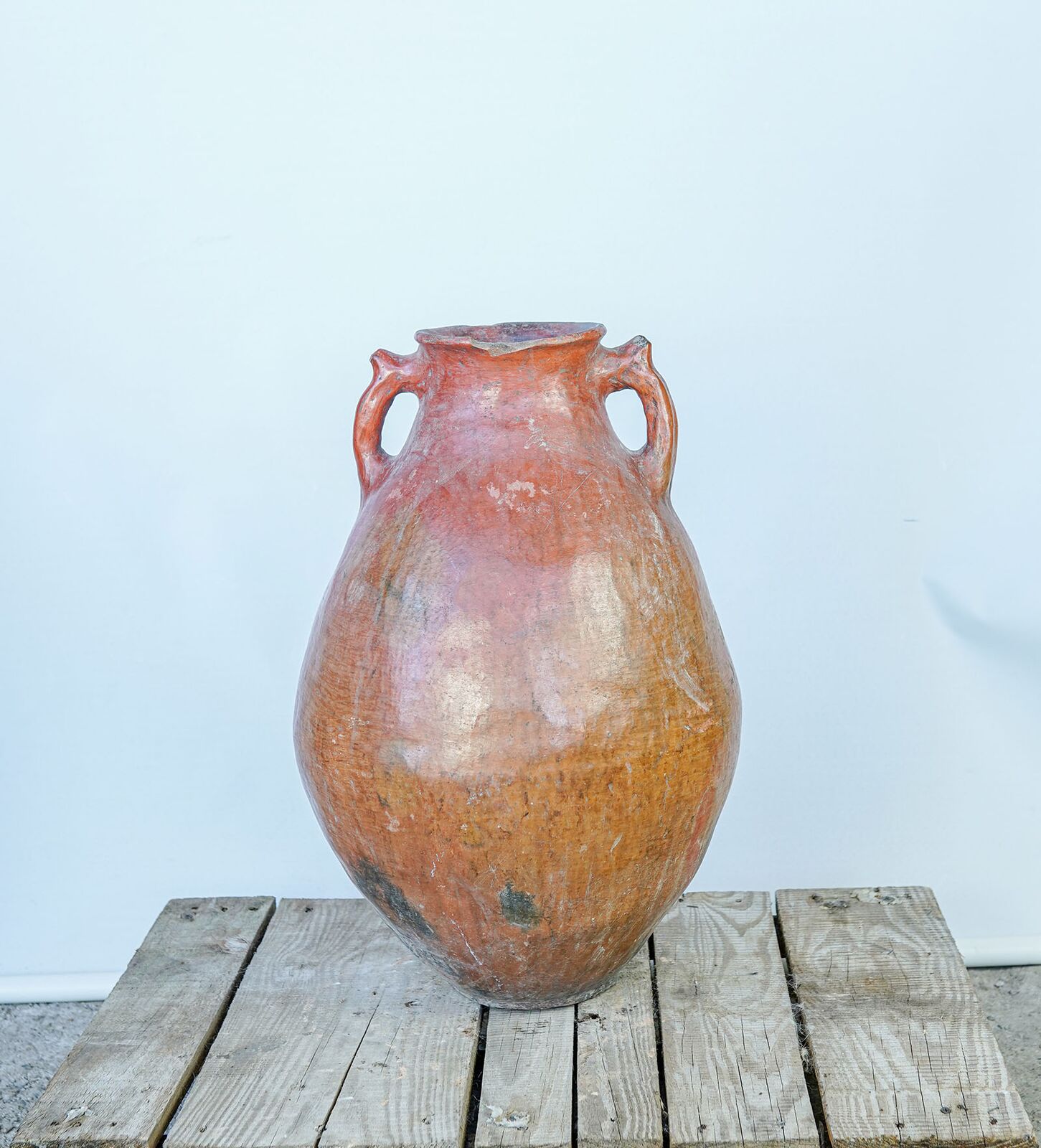 Erzurum Jar, Large — rounded orange-red glazed jar with two handles on a pallet