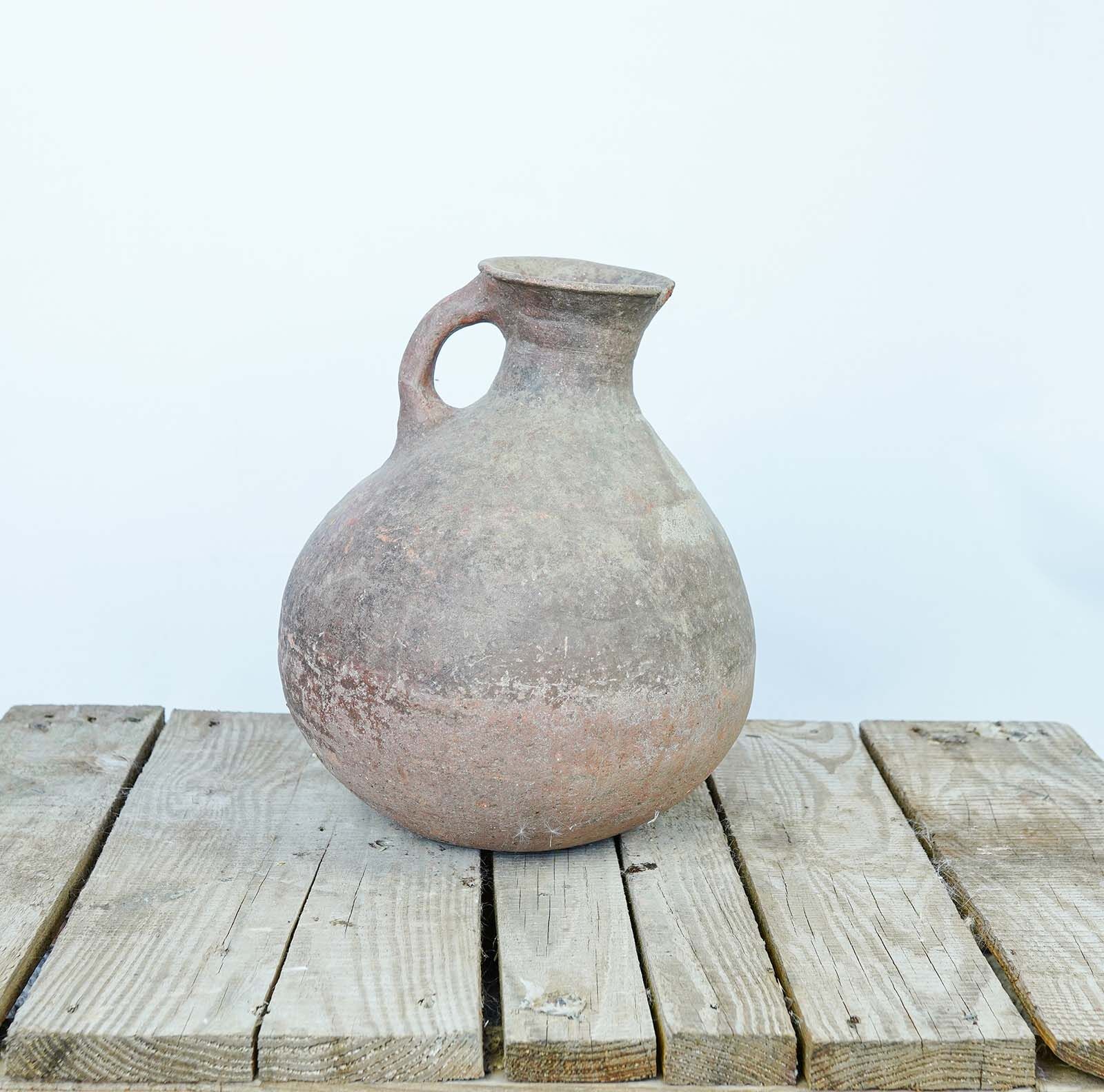 Eastern Single-Handled Jug — terracotta jug with one loop handle on a wooden pallet