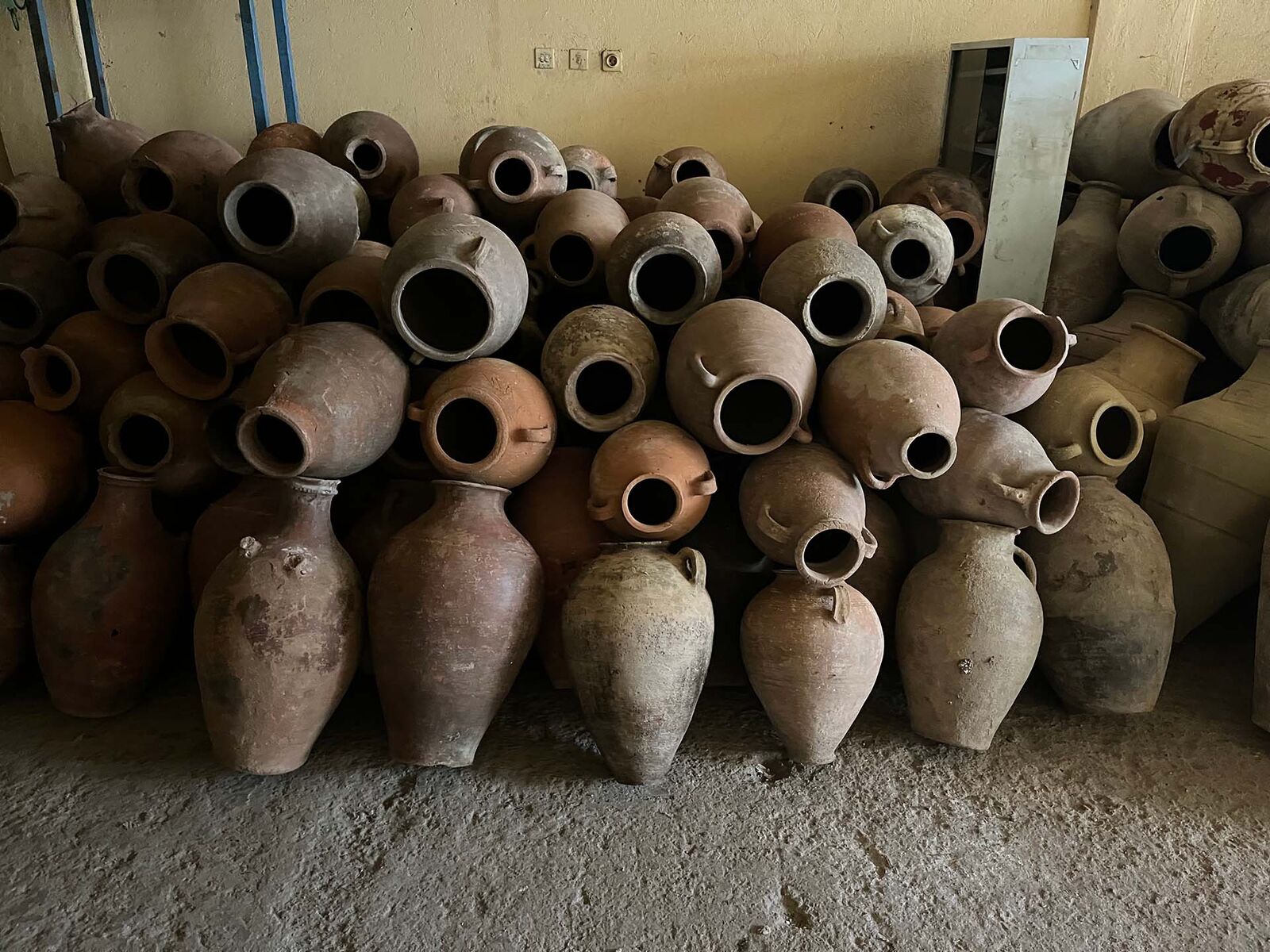 Eastern Four-Handled Jar, Extra Large — many clay jars stacked in a storeroom