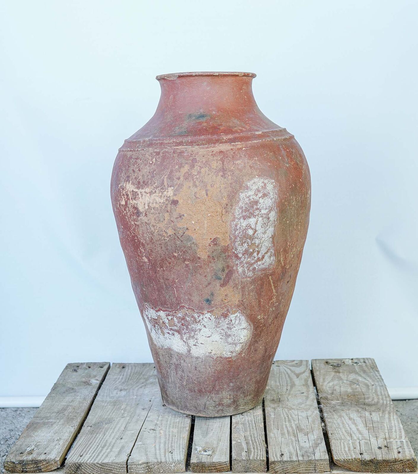 Eastern Handleless Jar — tall clay jar with a reddish weathered surface