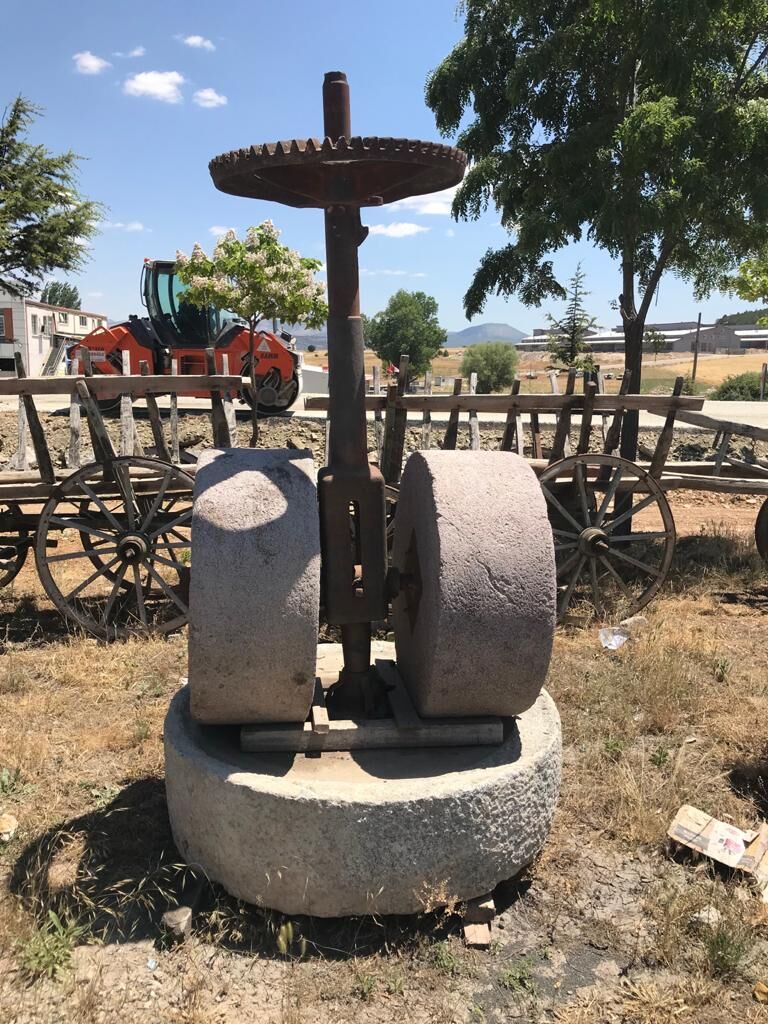 Olive Press Stone — stone mill wheel and iron gear wheel on a round stone base
