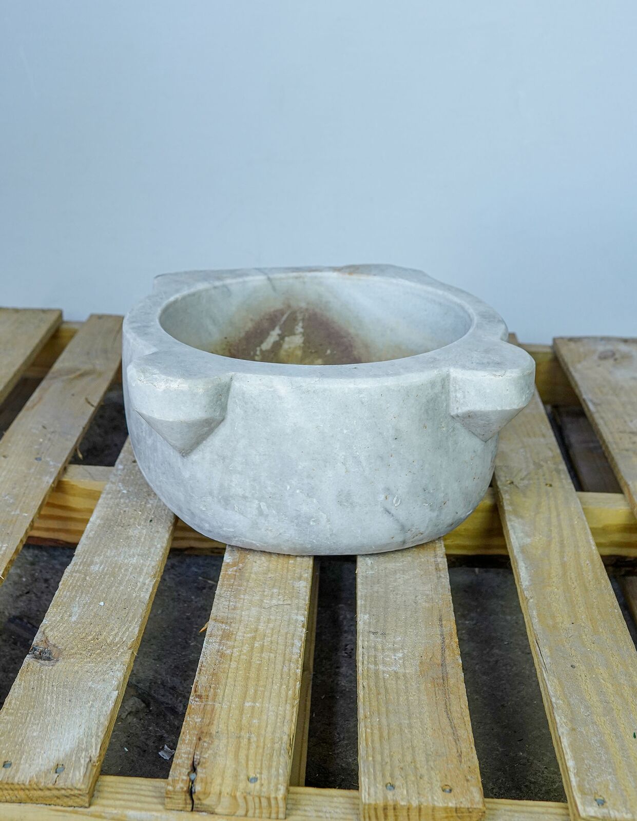 Marble Wash Basin — round marble hammam basin with side handles on a pallet