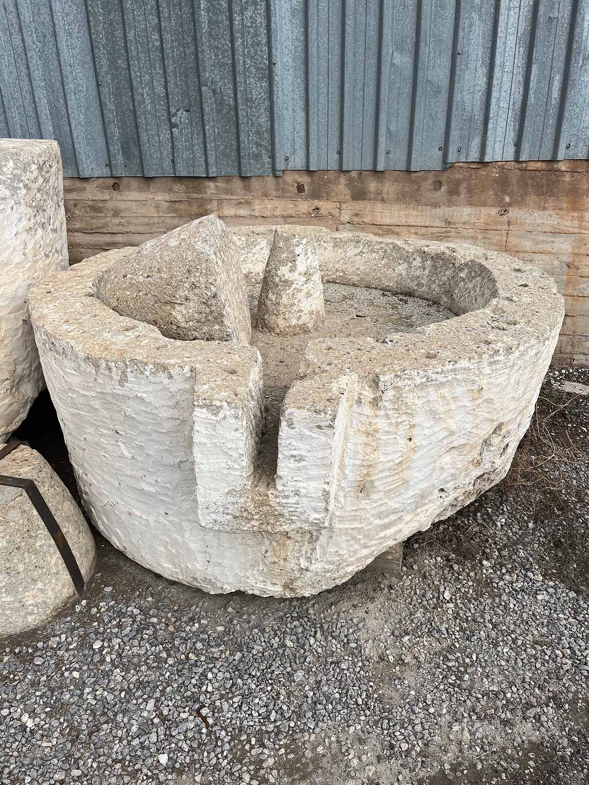 Carved Stone Basin — pale carved stone basin with a thick rim in a yard