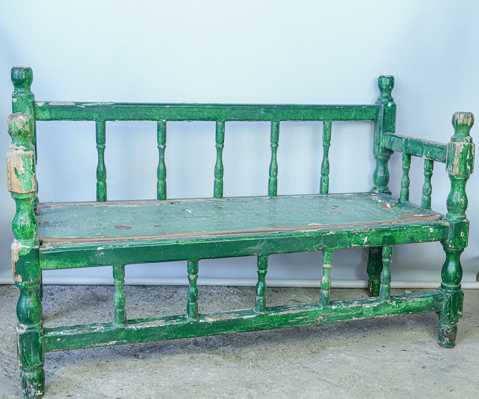 Wooden Garden Bench — green-painted wooden bench with a turned spindle back
