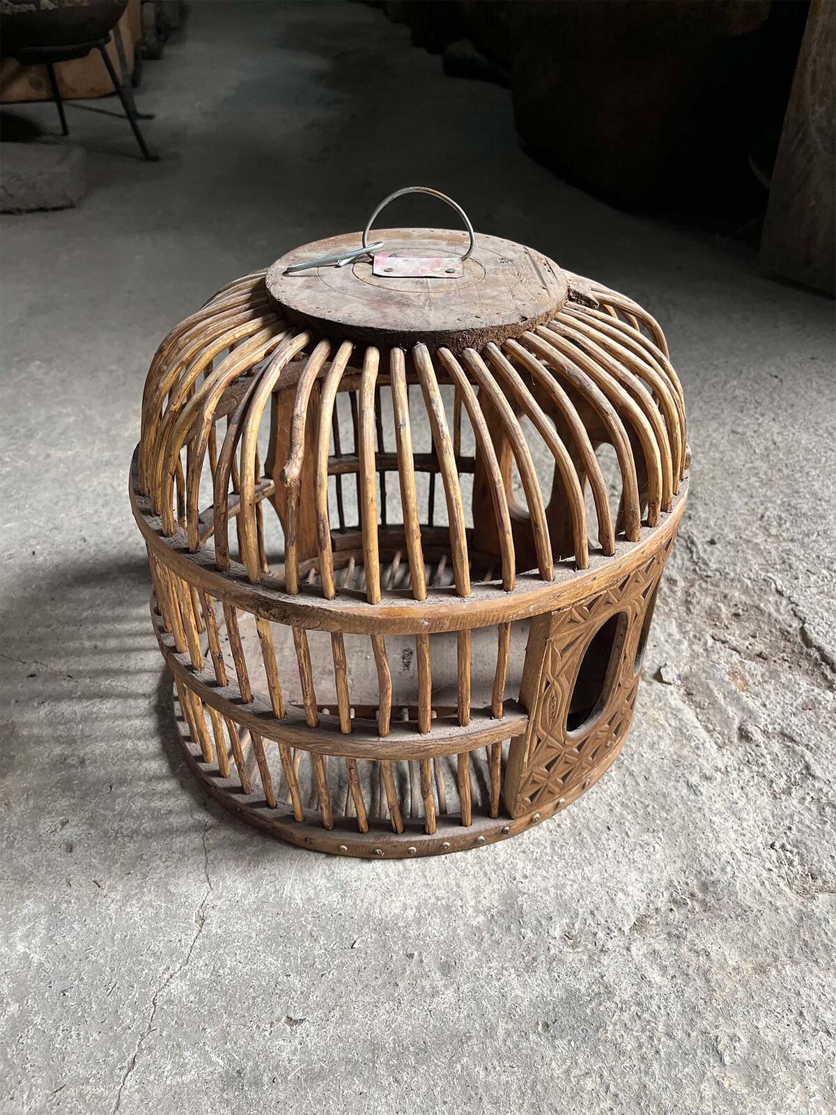 Woven Wooden Bird Cage — domed woven wooden bird cage in honey brown on a concrete floor