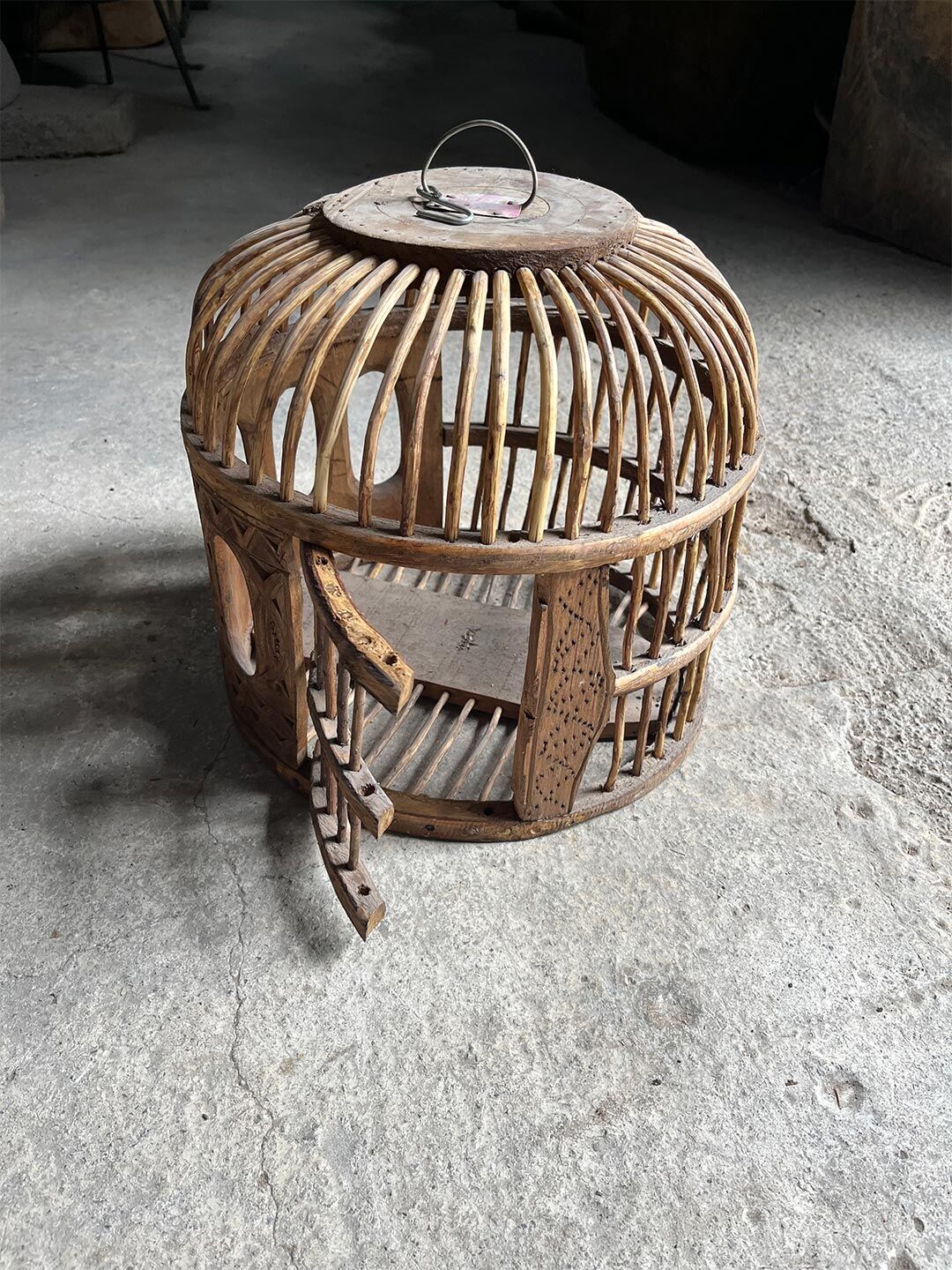 Woven Wooden Bird Cage — woven wooden bird cage with an open lattice on a concrete floor