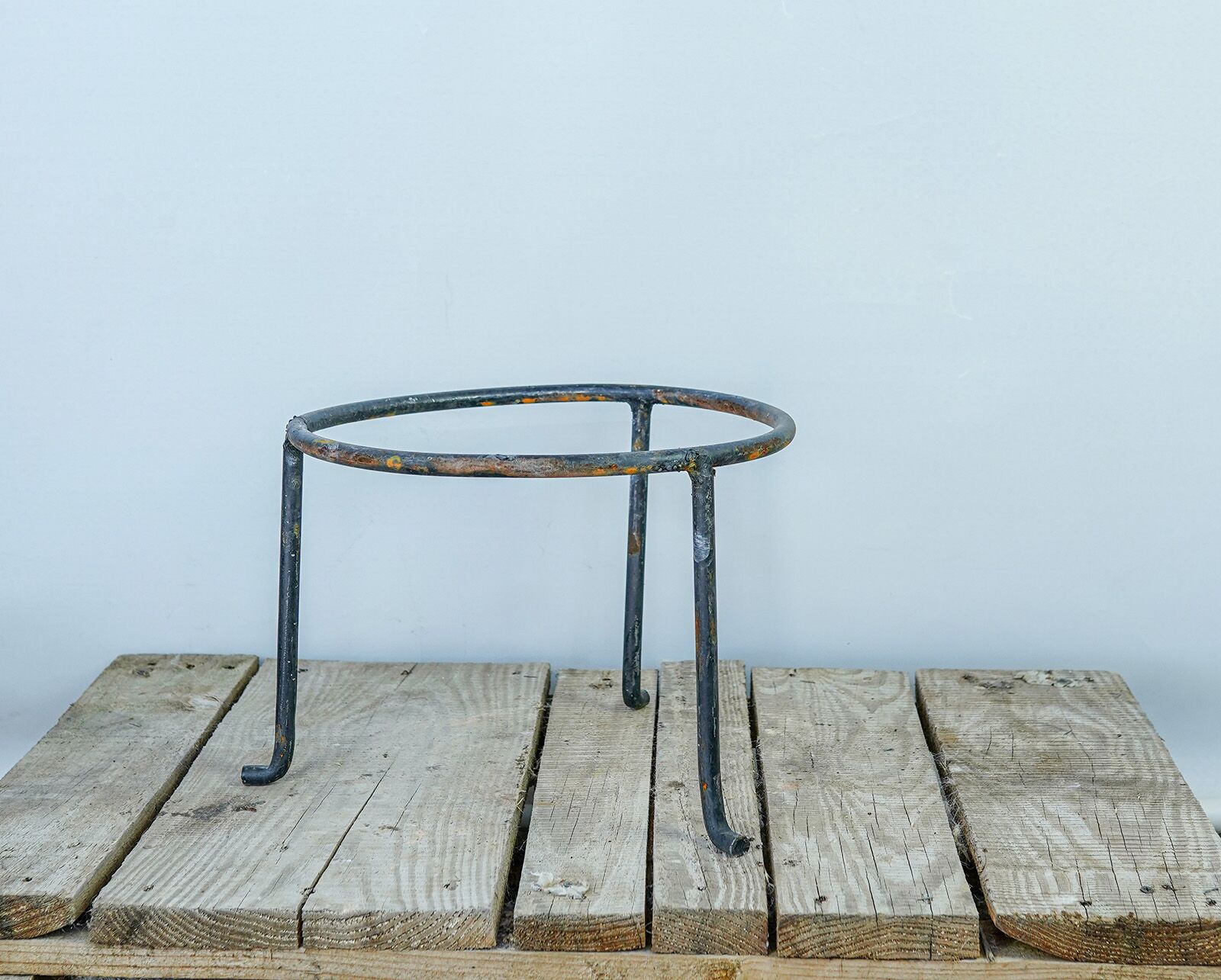 Wrought-Iron Jar Stand — dark iron jar stand with a round top ring on a pallet