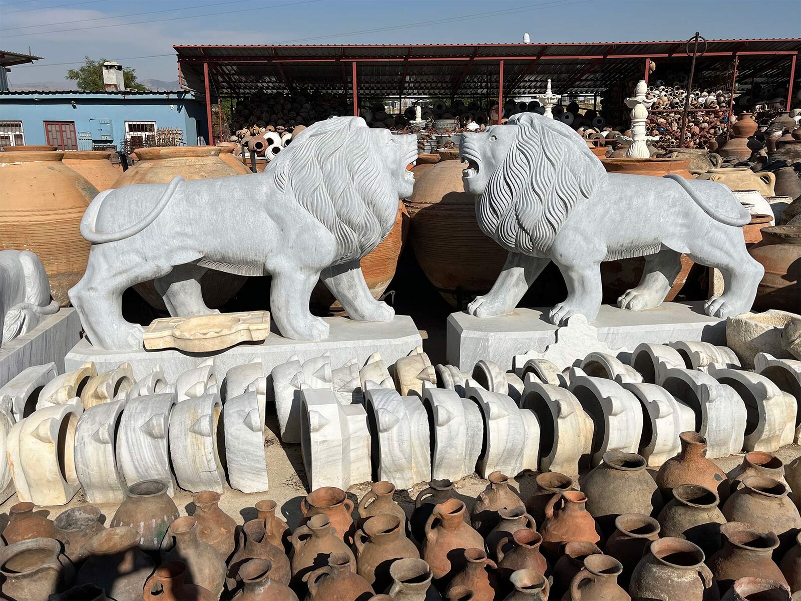 Marble Lion Statue — pair of white marble lions with carved manes on plinths