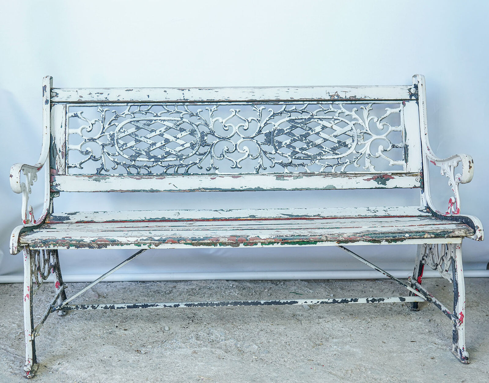 Cast-Iron Garden Bench — white painted bench with a pierced cast-iron back and scrolled arms