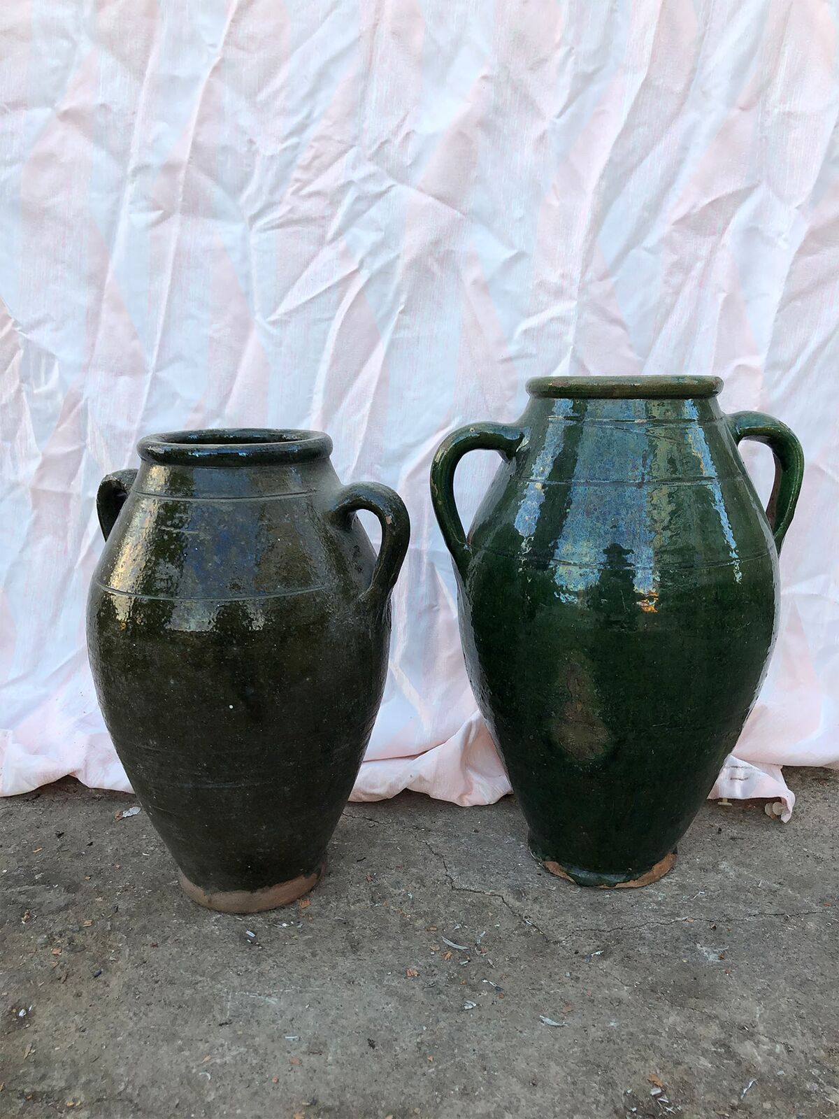 Antep Green Jar — pair of dark green glazed jars in front of a fabric backdrop