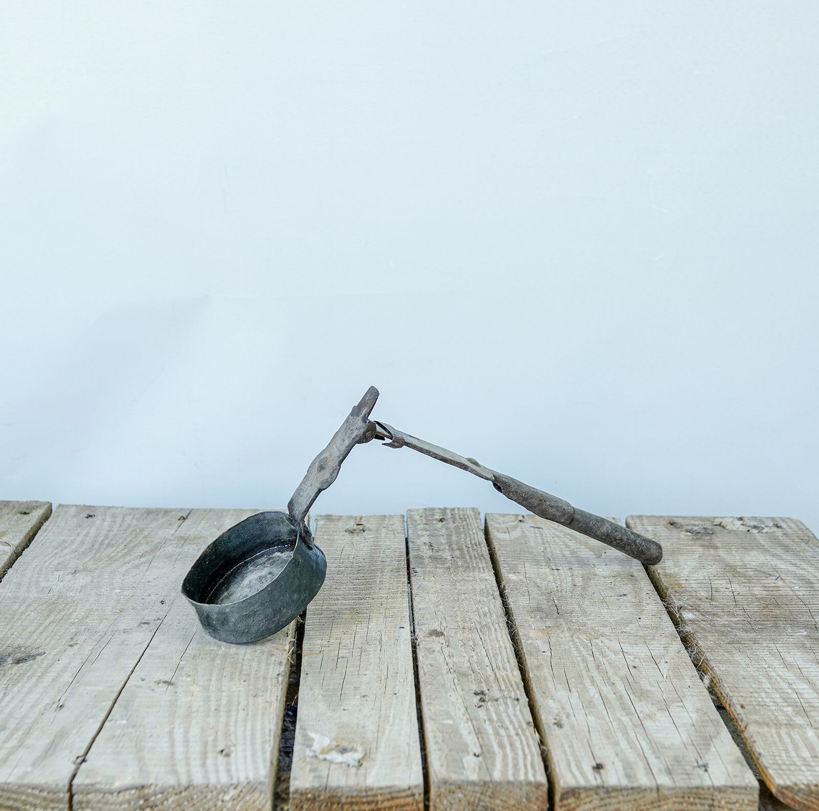 Long-Handled Iron Coffee Pot — small dark metal coffee pot with a long iron handle