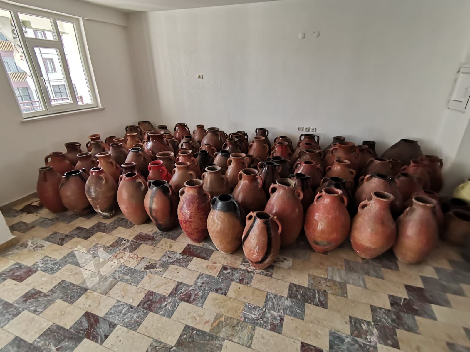 Bayburt-Erzurum Pot, Set I — rows of red and brown jars on a tiled floor