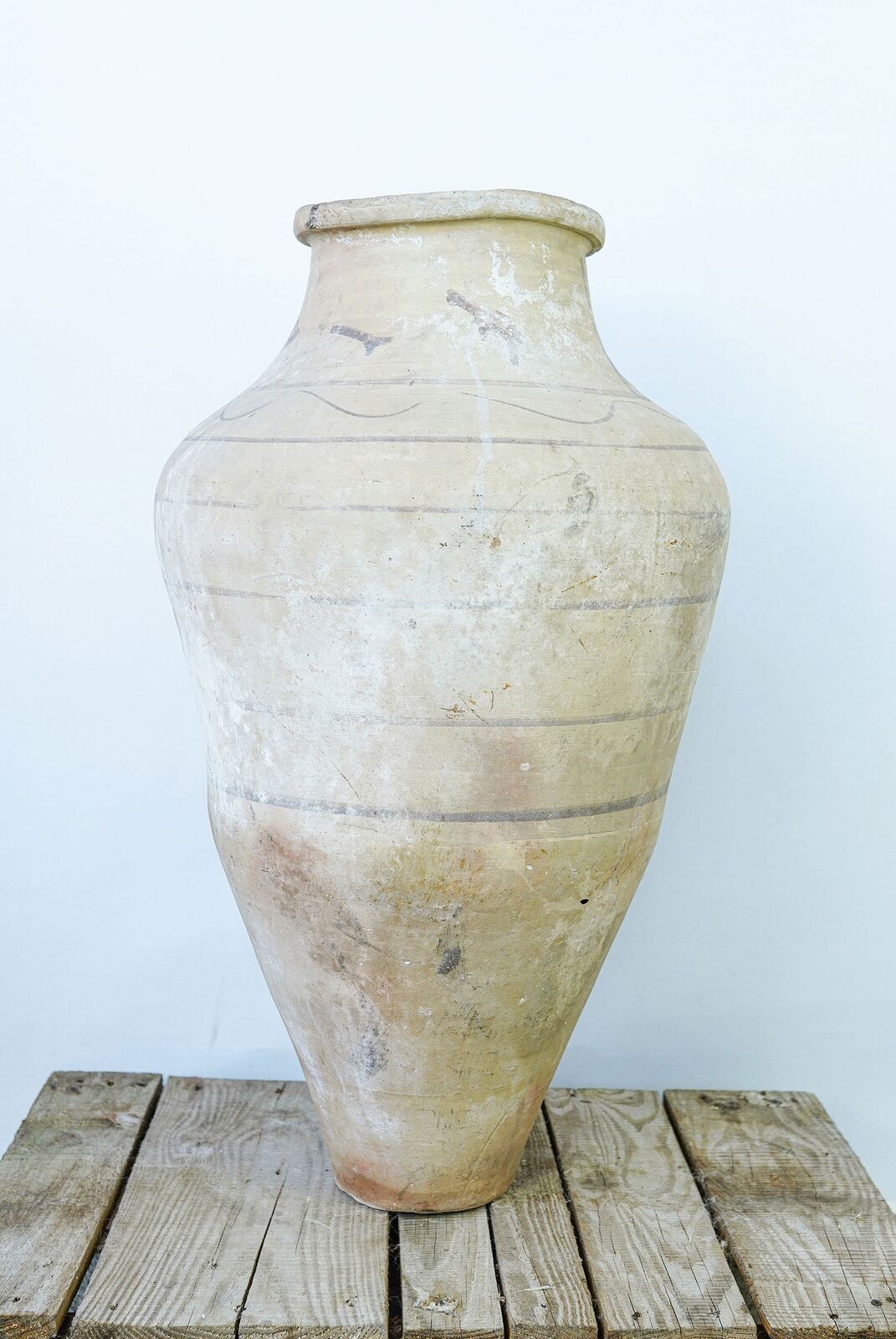 Avanos Pottery Jar — tall pale amphora with faint bands on a wooden pallet