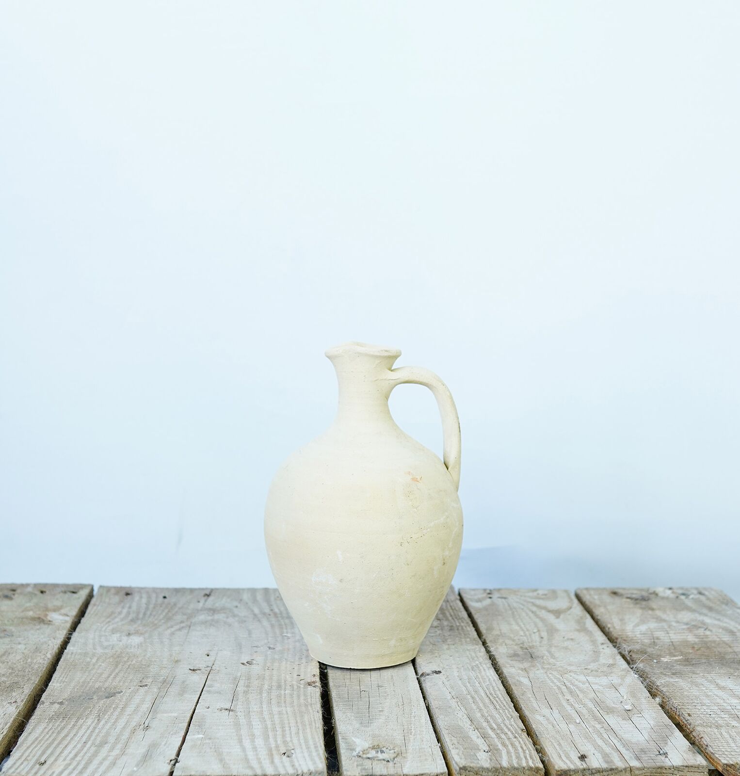 Avanos Water Jug — cream water jug with a narrow neck on a wooden pallet