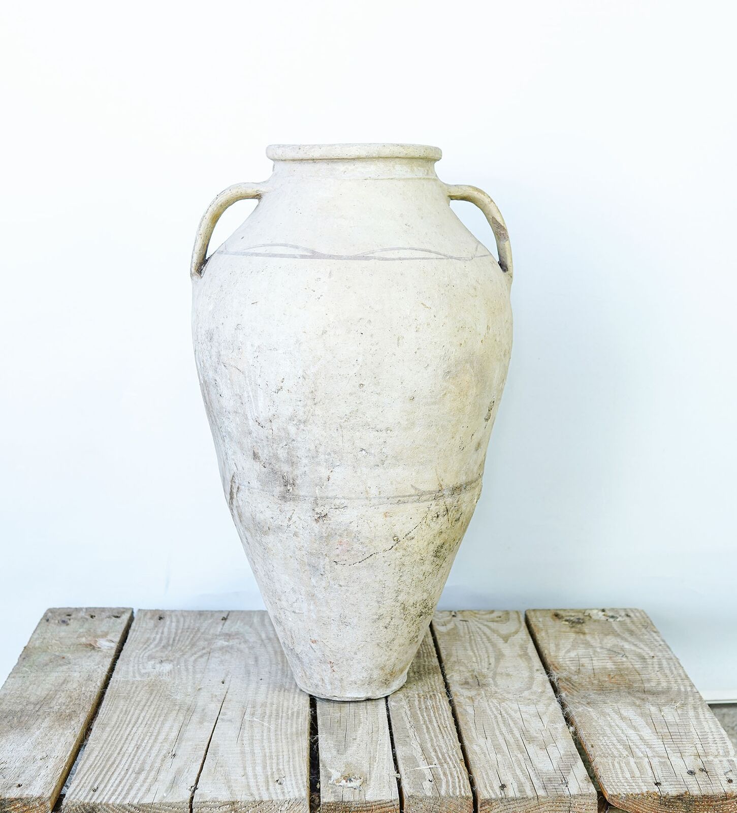 Avanos Two-Handled Amphora — pale clay amphora with two handles on a wooden pallet