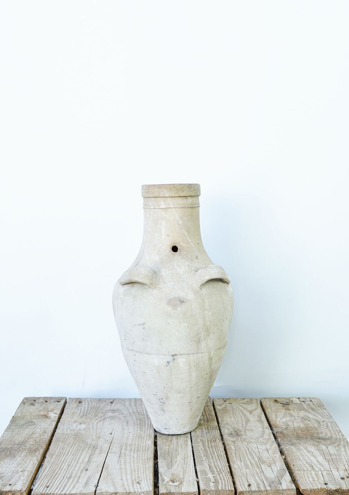 Avanos Churn Jar — tall slender cream clay jar with two small handles on a pallet