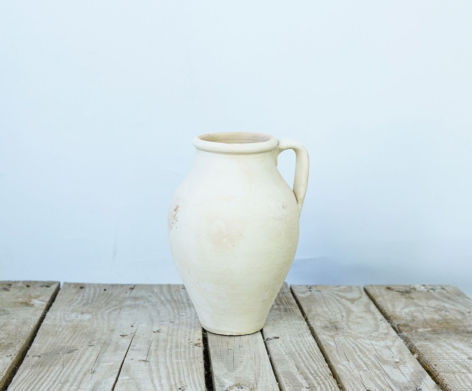 Avanos Pitcher — cream clay pitcher with a single handle on a wooden pallet