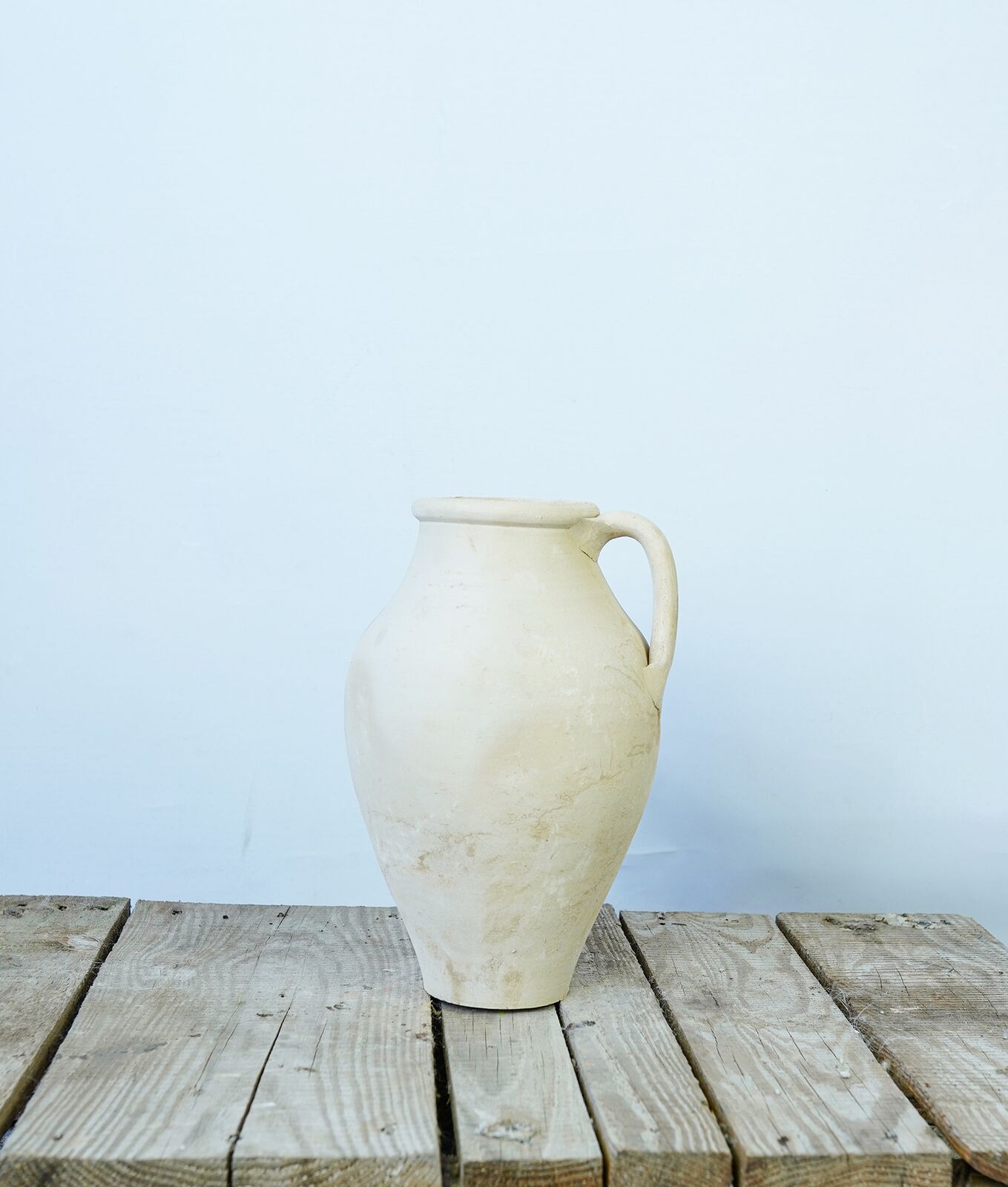 Avanos Pitcher — round-bellied cream pitcher with a pouring lip on a pallet