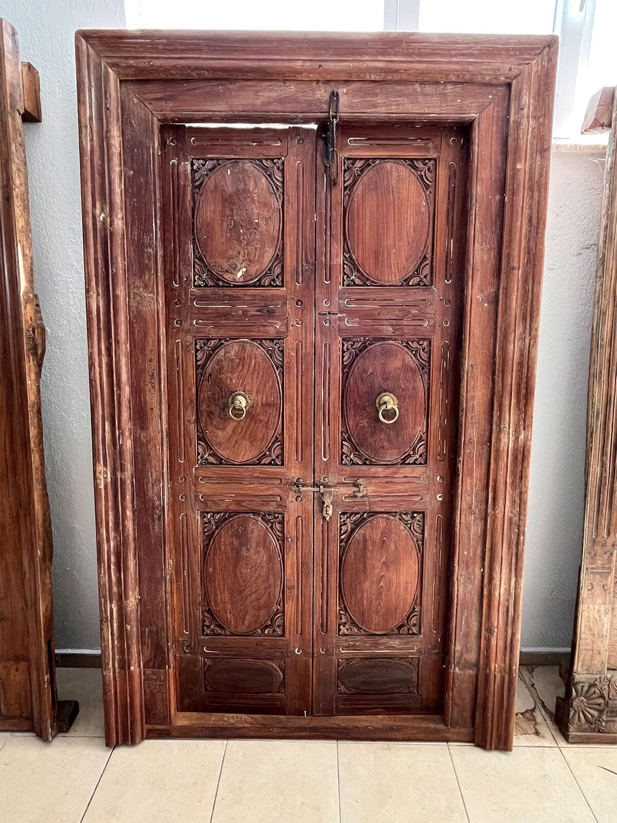 Panelled Door, Red-Brown — tall red-brown wooden door with raised panels on a pallet