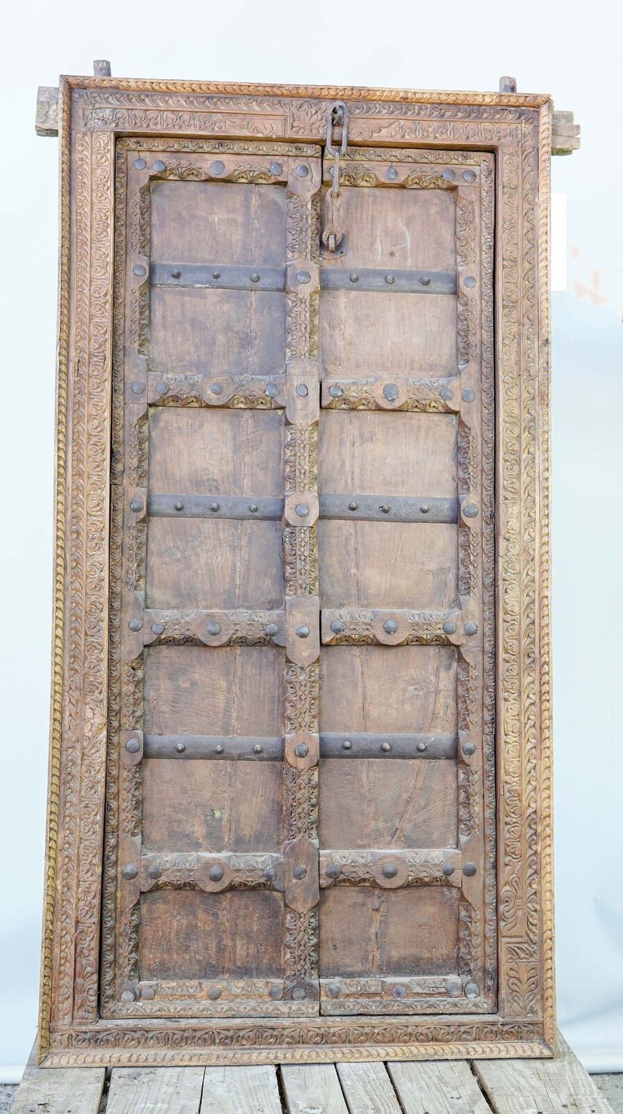 Carved Double Shutter — pair of carved wooden door leaves in a frame on a pallet