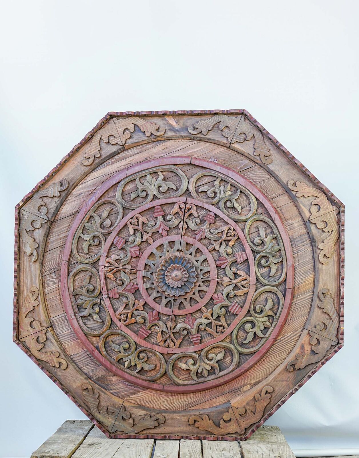 Carved Octagonal Ceiling Panel — octagonal wooden panel carved with a geometric rosette on a pallet