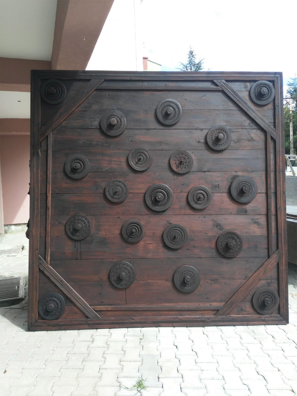 Studded Wood Panel, Dark — dark wooden panel set with a grid of round studs