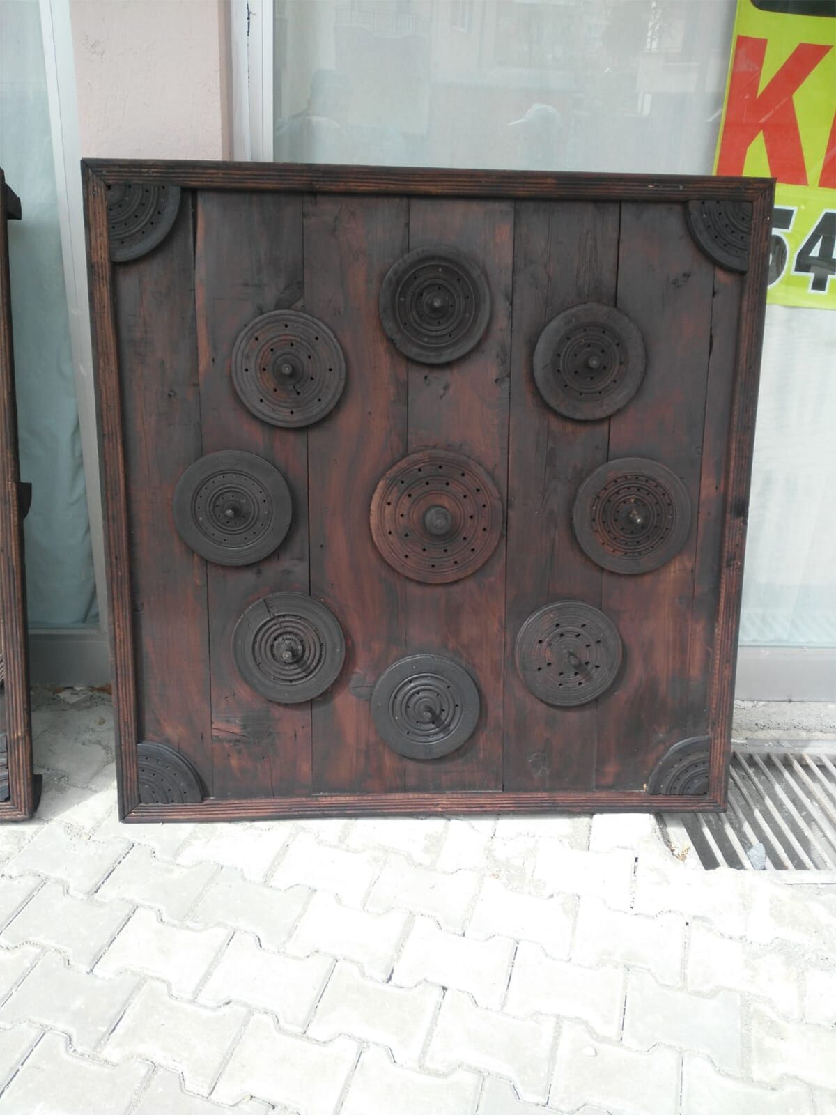 Studded Wood Panel, Dark — square dark wooden panel with studded circles and a plain border